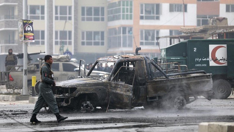 An Afghan man looks through a glass window damaged after a bombing attack in Kabul, Afghanistan, Sunday, Dec. 20, 2020. The strong car bomb explosion rocked the capital Kabul city on Sunday morning, killing multiple people, said a government official. (AP Photo/Rahmat Gul)