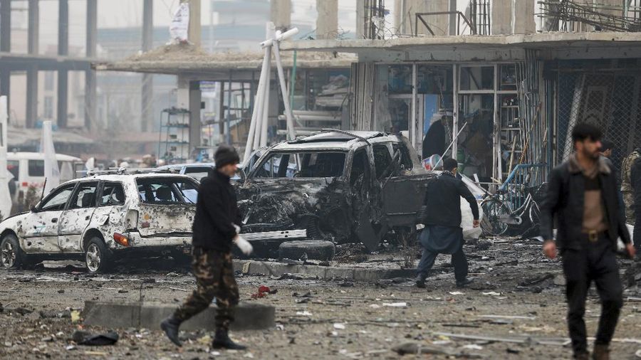 An Afghan man looks through a glass window damaged after a bombing attack in Kabul, Afghanistan, Sunday, Dec. 20, 2020. The strong car bomb explosion rocked the capital Kabul city on Sunday morning, killing multiple people, said a government official. (AP Photo/Rahmat Gul)