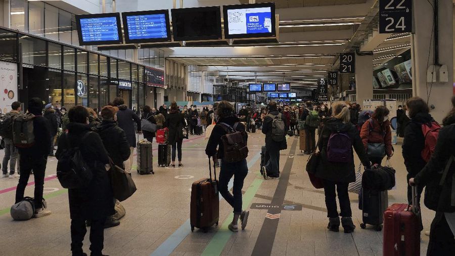 Travelers board a train at the Gare de Lyon station on the first day of the Christmas holiday season, in Paris, France, Saturday, Dec. 19, 2020. France lifted a lockdown imposed on 28 November, but strict measures are still in place as infections are still high. The nationwide curfew from 20:00 to 06:00 will be lifted on Christmas Eve but not on New Year's Eve. (AP Photo/Christophe Ena)