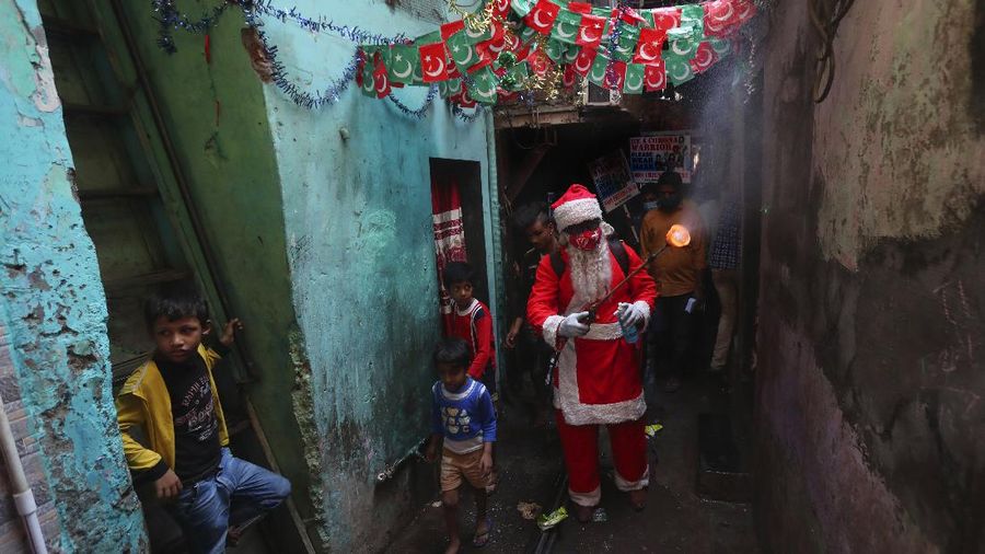 Santa, Robert Carroll, M.D., an Emergency Medicine Specialist with Manchester Memorial Hospital, administers the Pfizer-BioNTech vaccine to R.N. Diana Flebeau, a front-line healthcare worker, Wednesday, Dec. 16, 2020, in Manchester, Conn.   (Jim Michaud/Journal Inquirer via AP)