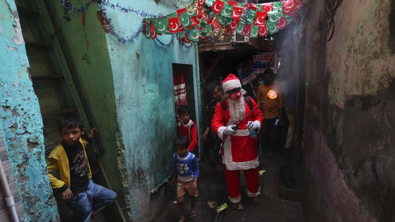 Santa, Robert Carroll, M.D., an Emergency Medicine Specialist with Manchester Memorial Hospital, administers the Pfizer-BioNTech vaccine to R.N. Diana Flebeau, a front-line healthcare worker, Wednesday, Dec. 16, 2020, in Manchester, Conn.   (Jim Michaud/Journal Inquirer via AP)