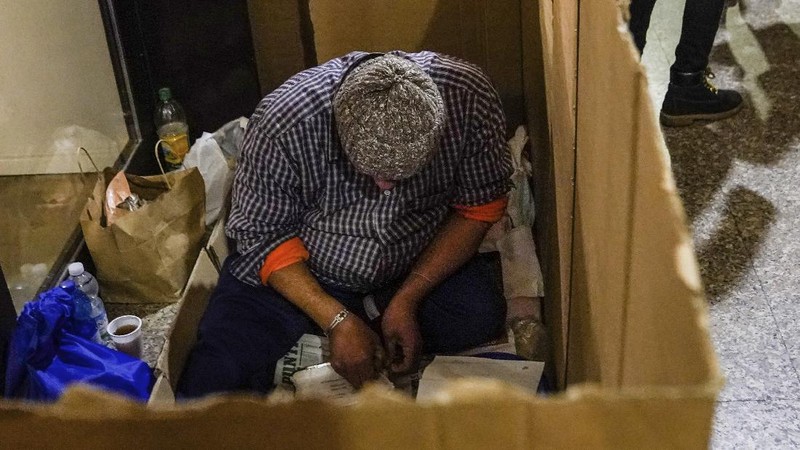 A homeless sleeps on the floor in front of a fashion store in downtown Milan, northern Italy, Friday, Nov. 27, 2020. Nowhere in Italy is poverty more evident than in Lombardy, the northern region that has been the pandemic epicenter in both surges. The Coldiretti agriculture lobby estimates that the virus has created 300,000 so-called 