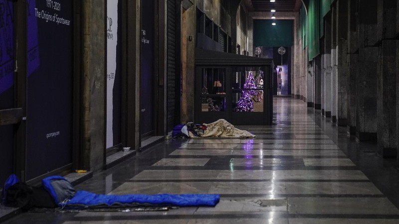 A homeless sleeps on the floor in front of a fashion store in downtown Milan, northern Italy, Friday, Nov. 27, 2020. Nowhere in Italy is poverty more evident than in Lombardy, the northern region that has been the pandemic epicenter in both surges. The Coldiretti agriculture lobby estimates that the virus has created 300,000 so-called 