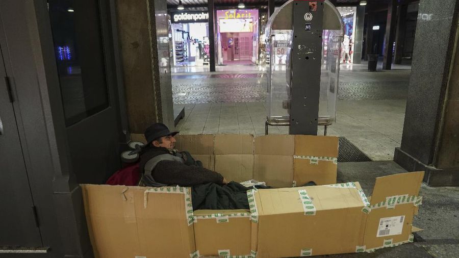 A homeless sleeps on the floor in front of a fashion store in downtown Milan, northern Italy, Friday, Nov. 27, 2020. Nowhere in Italy is poverty more evident than in Lombardy, the northern region that has been the pandemic epicenter in both surges. The Coldiretti agriculture lobby estimates that the virus has created 300,000 so-called 