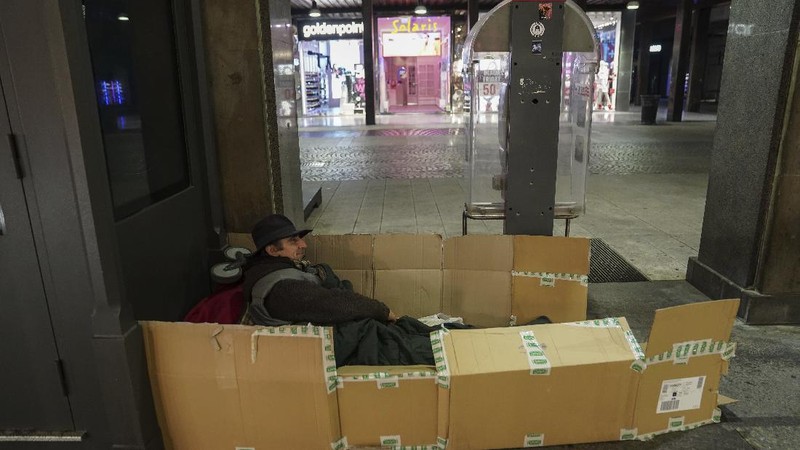 A homeless sleeps on the floor in front of a fashion store in downtown Milan, northern Italy, Friday, Nov. 27, 2020. Nowhere in Italy is poverty more evident than in Lombardy, the northern region that has been the pandemic epicenter in both surges. The Coldiretti agriculture lobby estimates that the virus has created 300,000 so-called 