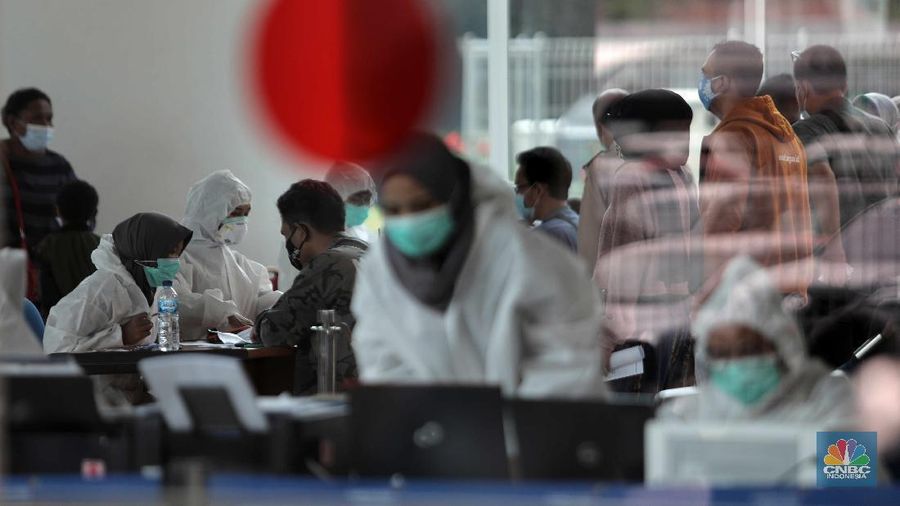 Antrean calon penumpang pesawat yang melakukan test rapid  di Shelter Kalayang Terminal 2 Bandara Soekarno-Hatta, Senin (21/12/2020). Antren panjang ini terjadi karena banyak penumpang yang ingin melakukan rapid test antigen yang disediakan pihak bandara. Terminal 2 Bandara Soekarno Hatta sempat ramai tadi pagi. Antrean mengular karena antrean rapid test penumpang. Pantauan վ pukul 11.30 terlihat antrian namun sudah kondusif. Sejumlah calon penumpang yang menunggu di luar area ruang test bisa duduk. Jelang liburan Natal dan akhir tahun, pemerintah menerapkan syarat minimal berupa hasil tes rapid antigen bagi traveler yang mau bepergian naik kereta api, pesawat terbang hingga kendaraan pribadi. (վ/ Muhammad Sabki)