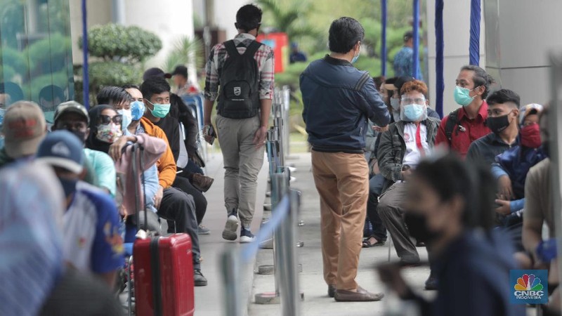 Antrean calon penumpang pesawat yang melakukan test rapid  di Shelter Kalayang Terminal 2 Bandara Soekarno-Hatta, Senin (21/12/2020). Antren panjang ini terjadi karena banyak penumpang yang ingin melakukan rapid test antigen yang disediakan pihak bandara. Terminal 2 Bandara Soekarno Hatta sempat ramai tadi pagi. Antrean mengular karena antrean rapid test penumpang. Pantauan CNBC pukul 11.30 terlihat antrian namun sudah kondusif. Sejumlah calon penumpang yang menunggu di luar area ruang test bisa duduk. Jelang liburan Natal dan akhir tahun, pemerintah menerapkan syarat minimal berupa hasil tes rapid antigen bagi traveler yang mau bepergian naik kereta api, pesawat terbang hingga kendaraan pribadi. (CNBC Indonesia/ Muhammad Sabki)