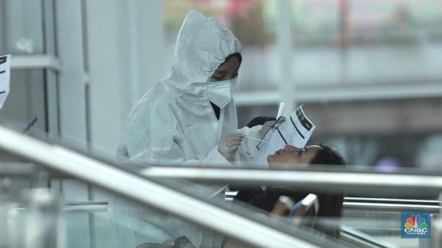 Antrean calon penumpang pesawat yang melakukan test rapid  di Shelter Kalayang Terminal 2 Bandara Soekarno-Hatta, Senin (21/12/2020). Antren panjang ini terjadi karena banyak penumpang yang ingin melakukan rapid test antigen yang disediakan pihak bandara. Terminal 2 Bandara Soekarno Hatta sempat ramai tadi pagi. Antrean mengular karena antrean rapid test penumpang. Pantauan վ pukul 11.30 terlihat antrian namun sudah kondusif. Sejumlah calon penumpang yang menunggu di luar area ruang test bisa duduk. Jelang liburan Natal dan akhir tahun, pemerintah menerapkan syarat minimal berupa hasil tes rapid antigen bagi traveler yang mau bepergian naik kereta api, pesawat terbang hingga kendaraan pribadi. (վ/ Muhammad Sabki)