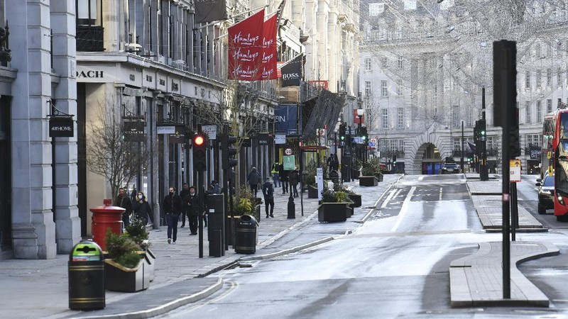 People walk through Cardiff city centre, Sunday Dec. 20, 2020. In Wales, authorities said they decided to move up a lockdown planned for after Christmas and people must stay at home from 12:01 a.m. Sunday. The move will largely scrap Christmas gatherings in line with the rules for southern England. (Ben Birchall/PA via AP)