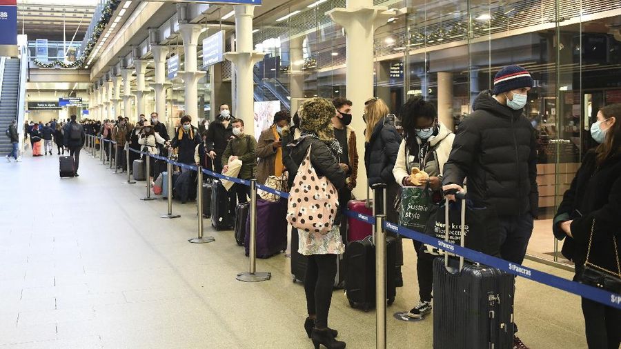 People at St Pancras station in London, wait to board the last train to Paris today, Sunday Dec. 20, 2020. Millions of people in England have learned they must cancel their Christmas get-togethers and holiday shopping trips. British Prime Minister Boris Johnson said Saturday that holiday gatherings can’t go ahead and non-essential shops must close in London and much of southern England. (Stefan Rousseau/PA via AP)