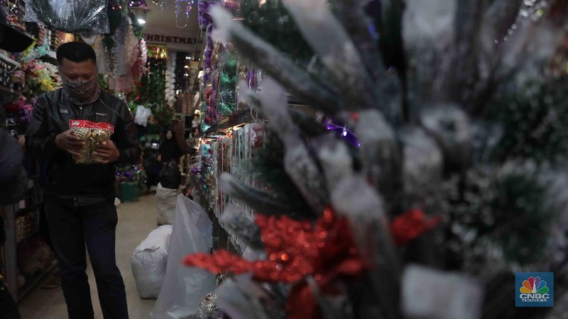 Calon pembeli memilih hiasan Natal di Pasar Asemka, Jakarta, Selasa, 22 Desember 2020. Berbagai pernak-pernik Natal untuk hiasan pohon dan rumah dijual berkisar dari harga Rp 5 ribu hingga Rp 2 juta, kebanyakan berasal dari Tiongkok. Pasar Asemka, Jakarta Barat dapat menjadi rekomendasi bagi warga yang ingin menghiasi rumah dengan cantik namun dengan harga yang terjangkau. Terlebih, semua pernak-pernik natal sedang diskon. “Iya kami lagi diskon itu saja hiasan natal yang bulat-bulat satu pack isi 3 bola tadinya Rp 60 ribu kita diskon jadi Rp 35 ribu,” kata salah satu penjual, Menariknya, untuk pohon natal sendiri yang berukuran kecil (1 meter) pedagang memasang harga dari Rp 350 ribu hingga Rp 400 ribu. Lalu, pilihan warna pohon pun beragam di kawasan ini sehingga pembeli memiliki banyak pilihan. (CNBC Indonesia/ Muhammad Sabki)