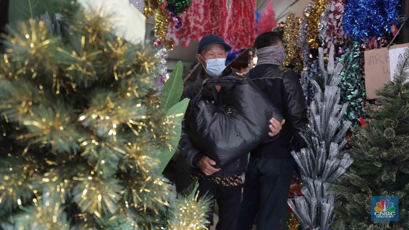 Calon pembeli memilih hiasan Natal di Pasar Asemka, Jakarta, Selasa, 22 Desember 2020. Berbagai pernak-pernik Natal untuk hiasan pohon dan rumah dijual berkisar dari harga Rp 5 ribu hingga Rp 2 juta, kebanyakan berasal dari Tiongkok. Pasar Asemka, Jakarta Barat dapat menjadi rekomendasi bagi warga yang ingin menghiasi rumah dengan cantik namun dengan harga yang terjangkau. Terlebih, semua pernak-pernik natal sedang diskon. “Iya kami lagi diskon itu saja hiasan natal yang bulat-bulat satu pack isi 3 bola tadinya Rp 60 ribu kita diskon jadi Rp 35 ribu,” kata salah satu penjual, Menariknya, untuk pohon natal sendiri yang berukuran kecil (1 meter) pedagang memasang harga dari Rp 350 ribu hingga Rp 400 ribu. Lalu, pilihan warna pohon pun beragam di kawasan ini sehingga pembeli memiliki banyak pilihan. (CNBC Indonesia/ Muhammad Sabki)