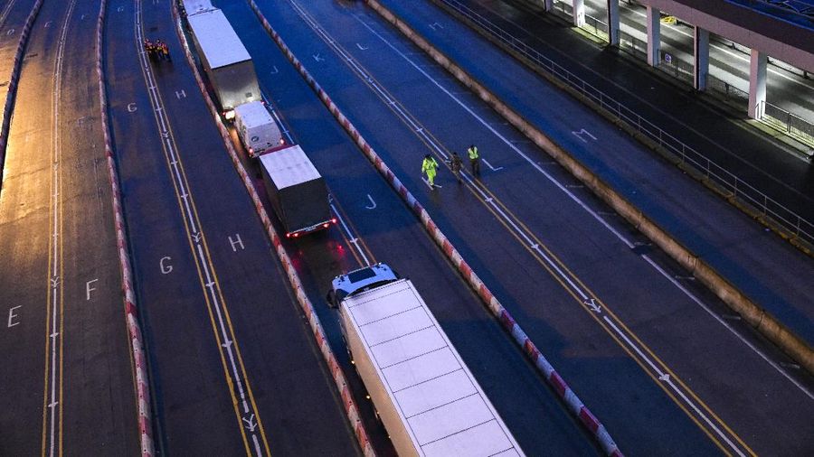 French officers make a COVID-19 test to a truck driver in the Port of Dover in Dover, England, Thursday, Dec. 24, 2020. Freight from Britain and passengers with a negative virus test have begun arriving on French shores, after France relaxed a two-day blockade over a new virus variant. The blockade had isolated Britain, stranded thousands of drivers and raised fears of shortages. (AP Photo/Alberto Pezzali)