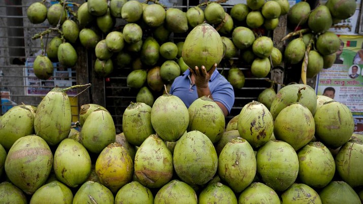 A Bangladeshi street vendor sells coconut on a street in Dhaka, Bangladesh, Wednesday, May 4, 2016.  Many Bangladeshi people drink coconut water in summer to beat the heat. (AP Photo/ A.M. Ahad)