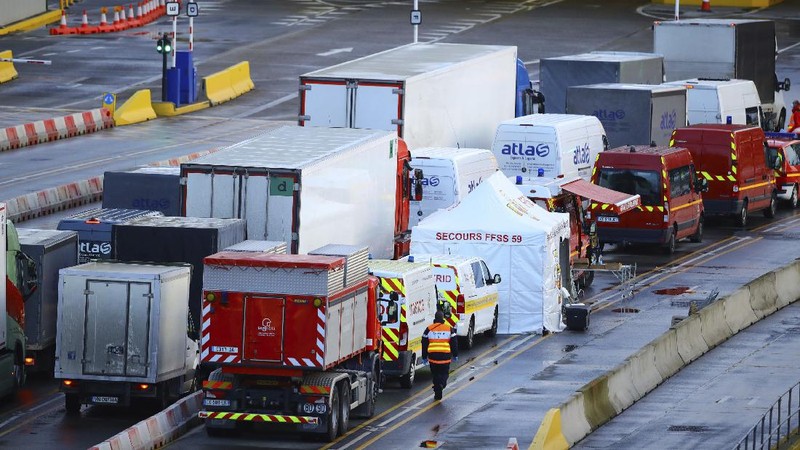 French officers make a COVID-19 test to a truck driver in the Port of Dover in Dover, England, Thursday, Dec. 24, 2020. Freight from Britain and passengers with a negative virus test have begun arriving on French shores, after France relaxed a two-day blockade over a new virus variant. The blockade had isolated Britain, stranded thousands of drivers and raised fears of shortages. (AP Photo/Alberto Pezzali)