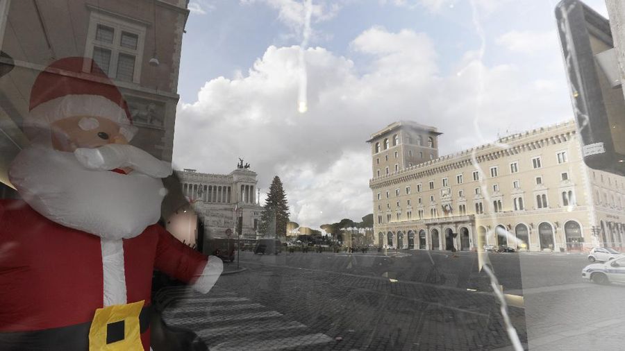 Police watch over as faithful pray outside St. Peter's Square, at the Vatican, Thursday, Dec. 24, 2020. Police in Italy are enforcing new COVID-19 travel restrictions aimed at limiting far-flung families from gathering over Christmas. Public health officials appealed for people to use common sense to prevent new infections over the holidays as a modified nationwide lockdown took effect Thursday. (AP Photo/Gregorio Borgia)