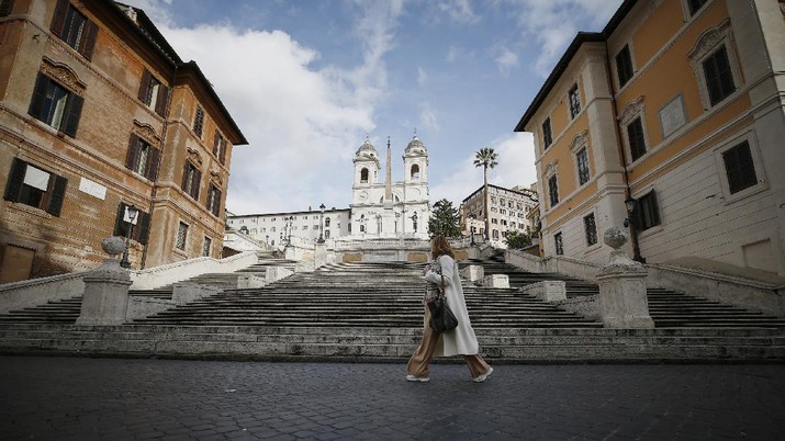 Virus Outbreak Italy Restrictions A woman walks past the Spanish Steps in Rome, Thursday, Dec. 24, 2020. Italy went into a modified nationwide lockdown Thursday for the Christmas and New Year period, with restrictions on personal movement and commercial activity similar to the 10 weeks of hard lockdown Italy imposed from March to May when the country became the epicenter of the outbreak in Europe. (Cecilia Fabiano/LaPresse via AP)