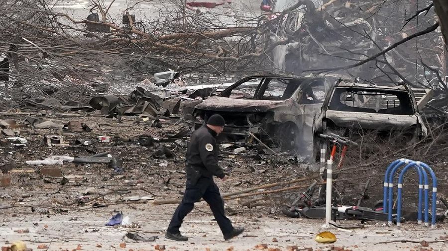 A law enforcement member walks past damage from an explosion in downtown Nashville, Tenn., Friday, Dec. 25, 2020. Buildings shook in the immediate area and beyond after a loud boom was heard early Christmas morning. (AP Photo/Mark Humphrey)