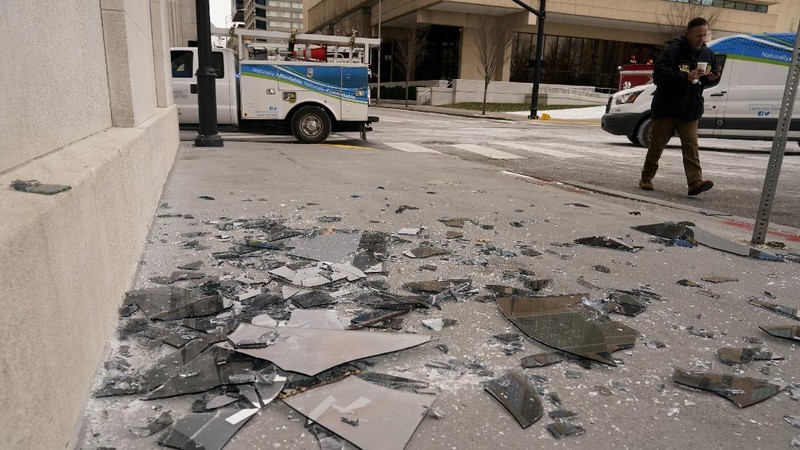 A law enforcement member walks past damage from an explosion in downtown Nashville, Tenn., Friday, Dec. 25, 2020. Buildings shook in the immediate area and beyond after a loud boom was heard early Christmas morning. (AP Photo/Mark Humphrey)