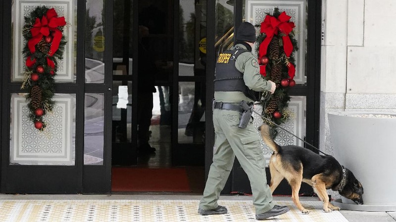 A law enforcement member walks past damage from an explosion in downtown Nashville, Tenn., Friday, Dec. 25, 2020. Buildings shook in the immediate area and beyond after a loud boom was heard early Christmas morning. (AP Photo/Mark Humphrey)