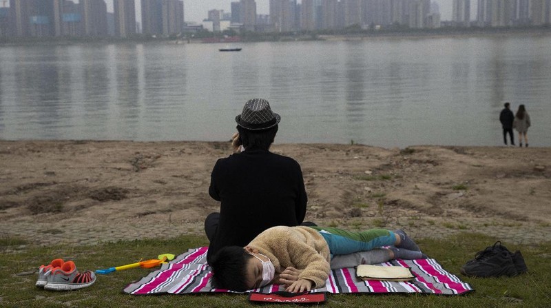 Foto terbaik AP 2020, Seorang anak yang mengenakan masker untuk melindungi diri dari virus korona berada di tepi Sungai Yangtze di Wuhan di provinsi Hubei China tengah pada. (AP/Ng Han Guan)