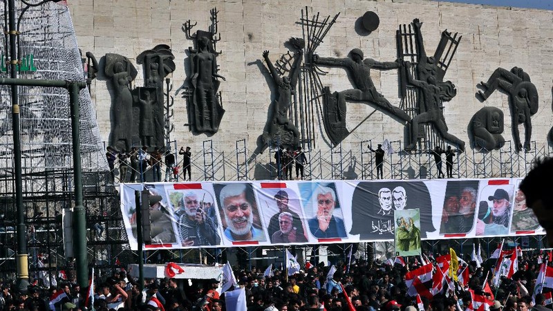 Supporters of the Popular Mobilization Forces hold a posters of Abu Mahdi al-Muhandis, deputy commander of the Popular Mobilization Forces, front, and General Qassem Soleimani, head of Iran's Quds force during a protest, in Tahrir Square, Iraq, Sunday, Jan. 3, 2021. Thousands of Iraqis converged on a landmark central square in Baghdad on Sunday to commemorate the anniversary of the killing of Soleimanil and al-Muhandis in a U.S. drone strike. (AP Photo/Khalid Moha
