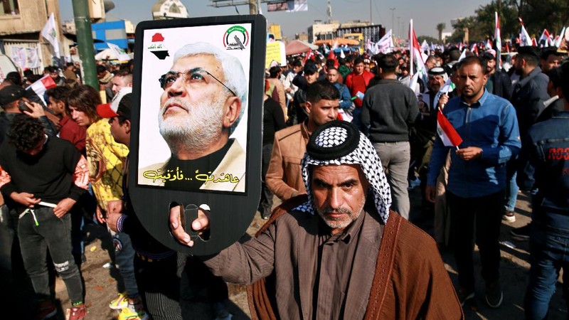 Supporters of the Popular Mobilization Forces hold a posters of Abu Mahdi al-Muhandis, deputy commander of the Popular Mobilization Forces, front, and General Qassem Soleimani, head of Iran's Quds force during a protest, in Tahrir Square, Iraq, Sunday, Jan. 3, 2021. Thousands of Iraqis converged on a landmark central square in Baghdad on Sunday to commemorate the anniversary of the killing of Soleimanil and al-Muhandis in a U.S. drone strike. (AP Photo/Khalid Moha
