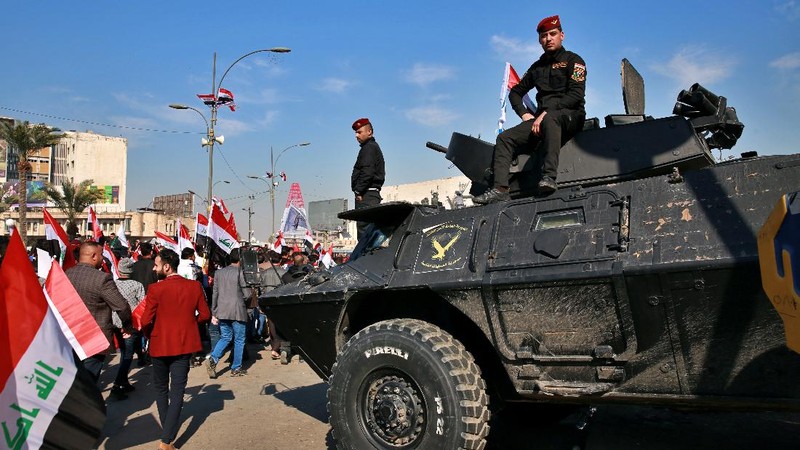 Supporters of the Popular Mobilization Forces hold a posters of Abu Mahdi al-Muhandis, deputy commander of the Popular Mobilization Forces, front, and General Qassem Soleimani, head of Iran's Quds force during a protest, in Tahrir Square, Iraq, Sunday, Jan. 3, 2021. Thousands of Iraqis converged on a landmark central square in Baghdad on Sunday to commemorate the anniversary of the killing of Soleimanil and al-Muhandis in a U.S. drone strike. (AP Photo/Khalid Moha