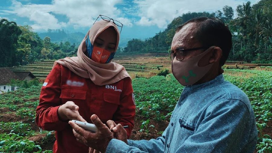 Pegawai BNI sedang berbincang-bincang dengan debitur Kredit Usaha Rakyat (KUR) BNI. Sebagai dukungan terhadap program ketahanan pangan, BNI memiliki program BNI Smartfarming yang dalam memastikan agar para petani mendapatkan akses pembiayaan yang murah dan mudah serta pendampingan yang memanfaatkan teknologi pertanian digital selama proses budidaya.