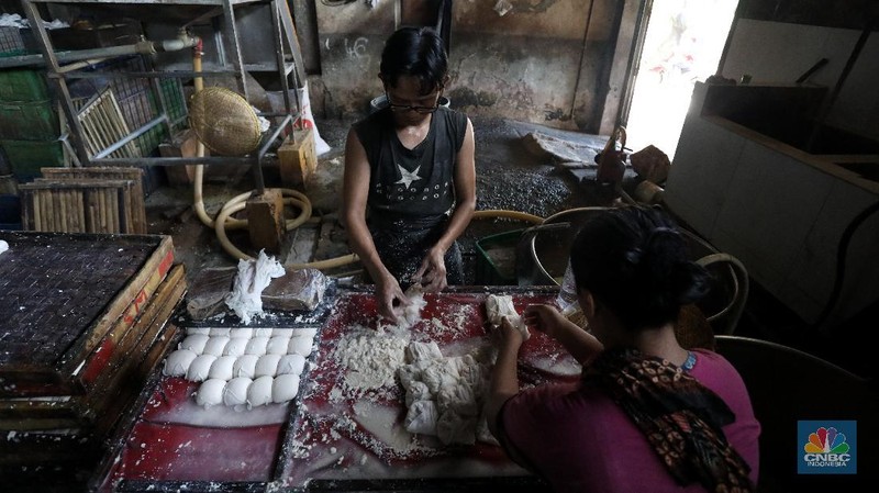 Pekerja beraktivitas di Rumah Produksi Tahu di kawasan Jakarta, Senin (4/1/2021). Produksi tahu di lokasi ini kembali dilanjutkan setelah beberapa hari belakangan mogok akibat naiknya harga kedelai yang mencapai Rp9.200 per kilogram dari harga normal Rp72.00 per kilogram. (CNBC Indonesia/Tri Susilo)