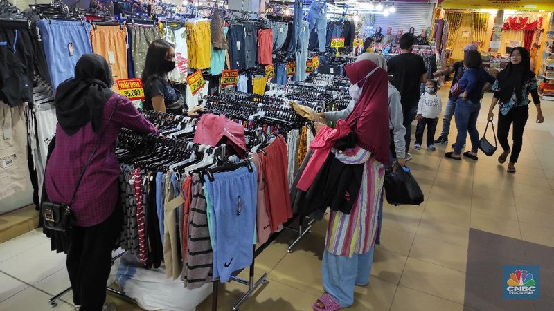 Pengunjung memlih pakaian yang dijual di salah satu pusat perbelanjaam di Kawasan Depok, Jawa Barat, Selasa (5/1/2021). Badan Pusat Statistik (BPS) memberi sinyal bahwa daya beli masyarakat mulai membaik karena salah satu indikatornya yakni inflasi komponen inti tumbuh positif mencapai 0,05 persen pada Desember 2020. (CNBC Indonesia/Andrean Kristianto)