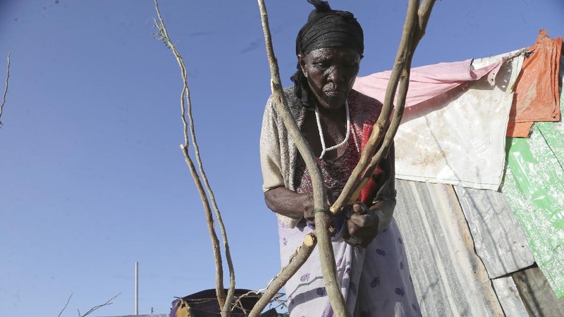 An internal displaced woman with her children cooks food near their makeshift shelter in Daynile camp in Mogadishu, Somalia on Thursday Dec. 17, 2020. As richer countries race to distribute COVID-19 vaccines, Somalia remains the rare place where much of the population hasn't taken the coronavirus seriously. Some fear that’s proven to be deadlier than anyone knows. (AP Photo/Farah Abdi Warsameh)
