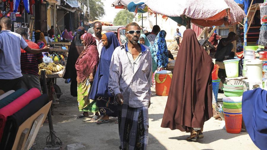 An internal displaced woman with her children cooks food near their makeshift shelter in Daynile camp in Mogadishu, Somalia on Thursday Dec. 17, 2020. As richer countries race to distribute COVID-19 vaccines, Somalia remains the rare place where much of the population hasn't taken the coronavirus seriously. Some fear that’s proven to be deadlier than anyone knows. (AP Photo/Farah Abdi Warsameh)