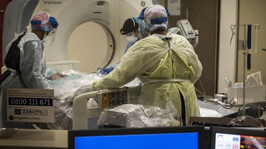 Medical workers prepare a COVID positive patient for a CT Scan at a clinic in Johannesburg Sunday, Dec. 27, 2020. South Africa's COVID-19 spike has taken the country to more than 1 million confirmed cases with hospitals reaching capacity and no sign of the new surge reaching a peak. (AP Photo/Shiraaz Mohamed.