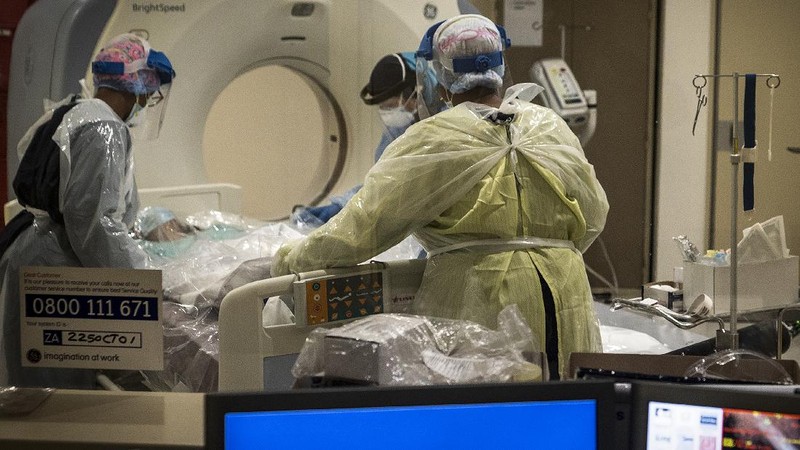 Medical workers prepare a COVID positive patient for a CT Scan at a clinic in Johannesburg Sunday, Dec. 27, 2020. South Africa's COVID-19 spike has taken the country to more than 1 million confirmed cases with hospitals reaching capacity and no sign of the new surge reaching a peak. (AP Photo/Shiraaz Mohamed.