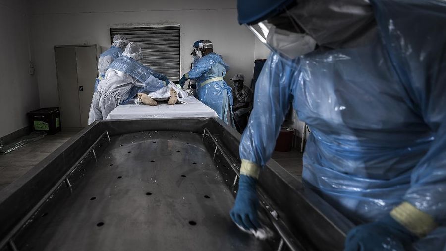 Medical workers prepare a COVID positive patient for a CT Scan at a clinic in Johannesburg Sunday, Dec. 27, 2020. South Africa's COVID-19 spike has taken the country to more than 1 million confirmed cases with hospitals reaching capacity and no sign of the new surge reaching a peak. (AP Photo/Shiraaz Mohamed.