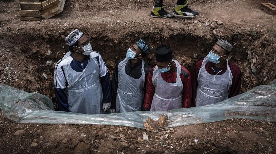 Members of the Saaberie Chishty Burial Society prepare the grave for the burial of a person who died from COVID-19 at the Avalon Cemetery in Lenasia, Johannesburg Saturday Dec. 26, 2020. South Africa’s health minister has announced an “alarming rate of spread” in the country, with more than 14,000 new confirmed coronavirus cases and more than 400 deaths reported Wednesday. It was the largest single-day increase in cases. (AP Photo/Shiraaz Mohamed)