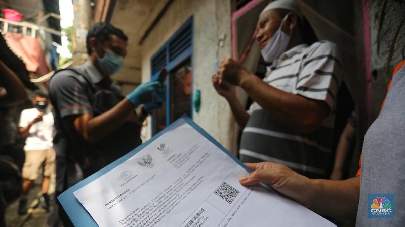Petugas Pos Indonesia menyalurkankan bantuan sosial (bansos) ke pemukiman di wilayah Kenari, Jakarta Pusat, Rabu (6/1/2021). Pemerintah telah meresmikan penyaluran bantuan tunai se-Indonesia hari ini.  (CNBC Indonesia/Andrean Kristianto)