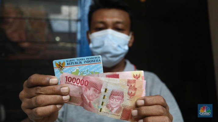 Petugas Pos Indonesia menyalurkankan bantuan sosial (bansos) ke pemukiman di wilayah Kenari, Jakarta Pusat, Rabu (6/1/2021). Pemerintah telah meresmikan penyaluran bantuan tunai se-Indonesia hari ini.  (CNBC Indonesia/Andrean Kristianto)