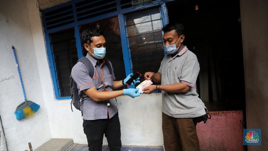 Petugas Pos Indonesia menyalurkankan bantuan sosial (bansos) ke pemukiman di wilayah Kenari, Jakarta Pusat, Rabu (6/1/2021). Pemerintah telah meresmikan penyaluran bantuan tunai se-Indonesia hari ini. (CNBC Indonesia/Andrean Kristianto)