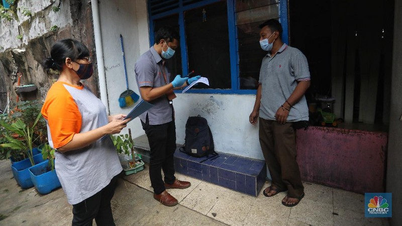 Petugas Pos Indonesia menyalurkankan bantuan sosial (bansos) ke pemukiman di wilayah Kenari, Jakarta Pusat, Rabu (6/1/2021). Pemerintah telah meresmikan penyaluran bantuan tunai se-Indonesia hari ini.  (CNBC Indonesia/Andrean Kristianto)
