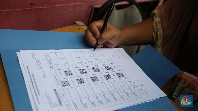 Petugas Pos Indonesia menyalurkankan bantuan sosial (bansos) ke pemukiman di wilayah Kenari, Jakarta Pusat, Rabu (6/1/2021). Pemerintah telah meresmikan penyaluran bantuan tunai se-Indonesia hari ini.  (CNBC Indonesia/Andrean Kristianto)