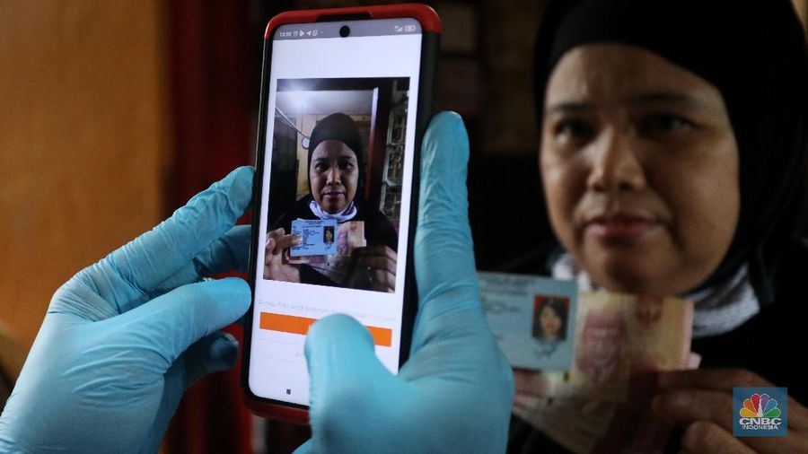 Petugas Pos Indonesia menyalurkankan bantuan sosial (bansos) ke pemukiman di wilayah Kenari, Jakarta Pusat, Rabu (6/1/2021). Pemerintah telah meresmikan penyaluran bantuan tunai se-Indonesia hari ini.  (CNBC Indonesia/Andrean Kristianto)