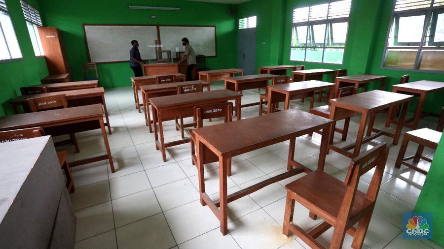 Penjaga sekolah membereskan ruang sekolah yang kosong di Depok, Jawa barat, Rabu (6/1/2021). Kegitan pembelajaran secara tatap muka di wilayah Jawa Barat yang direncanakan dimulai pada awal bulan Januari 2021 ditunda dengan batas waktu yang belum ditentukan akibat masih tingginya kasus Covid-19. (CNBC Indonesia/Tri Susilo).