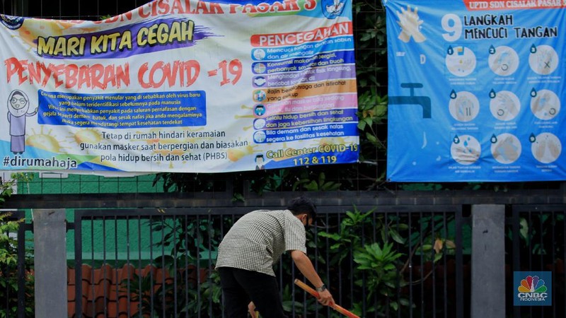 Penjaga sekolah membereskan ruang sekolah yang kosong di Depok, Jawa barat, Rabu (6/1/2021). Kegitan pembelajaran secara tatap muka di wilayah Jawa Barat yang direncanakan dimulai pada awal bulan Januari 2021 ditunda dengan batas waktu yang belum ditentukan akibat masih tingginya kasus Covid-19. (CNBC Indonesia/Tri Susilo).