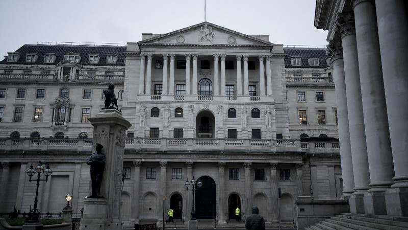 A man walks backdropped by the Bank of England in the City of London financial district in London, Jan. 5, 2021, on the first morning of England entering a third national lockdown since the coronavirus outbreak began. British Prime Minister Boris Johnson on Monday night announced a tough new stay-at-home order that will last at least six weeks, as authorities struggle to stem a surge in COVID-19 infections that threatens to overwhelm hospitals around the U.K. (AP Photo/Matt Dunham)