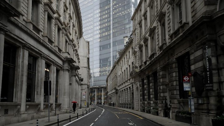 A man walks backdropped by the Bank of England in the City of London financial district in London, Jan. 5, 2021, on the first morning of England entering a third national lockdown since the coronavirus outbreak began. British Prime Minister Boris Johnson on Monday night announced a tough new stay-at-home order that will last at least six weeks, as authorities struggle to stem a surge in COVID-19 infections that threatens to overwhelm hospitals around the U.K. (AP Photo/Matt Dunham)