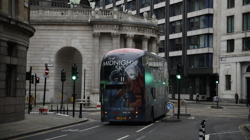 A man walks backdropped by the Bank of England in the City of London financial district in London, Jan. 5, 2021, on the first morning of England entering a third national lockdown since the coronavirus outbreak began. British Prime Minister Boris Johnson on Monday night announced a tough new stay-at-home order that will last at least six weeks, as authorities struggle to stem a surge in COVID-19 infections that threatens to overwhelm hospitals around the U.K. (AP Photo/Matt Dunham)