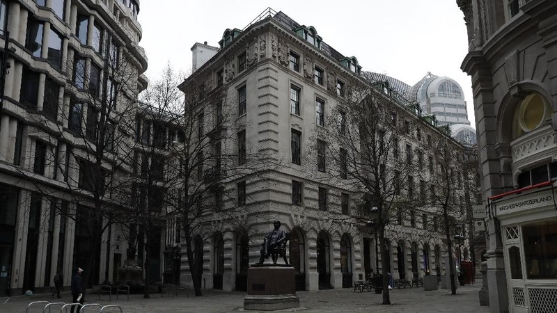 A man walks backdropped by the Bank of England in the City of London financial district in London, Jan. 5, 2021, on the first morning of England entering a third national lockdown since the coronavirus outbreak began. British Prime Minister Boris Johnson on Monday night announced a tough new stay-at-home order that will last at least six weeks, as authorities struggle to stem a surge in COVID-19 infections that threatens to overwhelm hospitals around the U.K. (AP Photo/Matt Dunham)