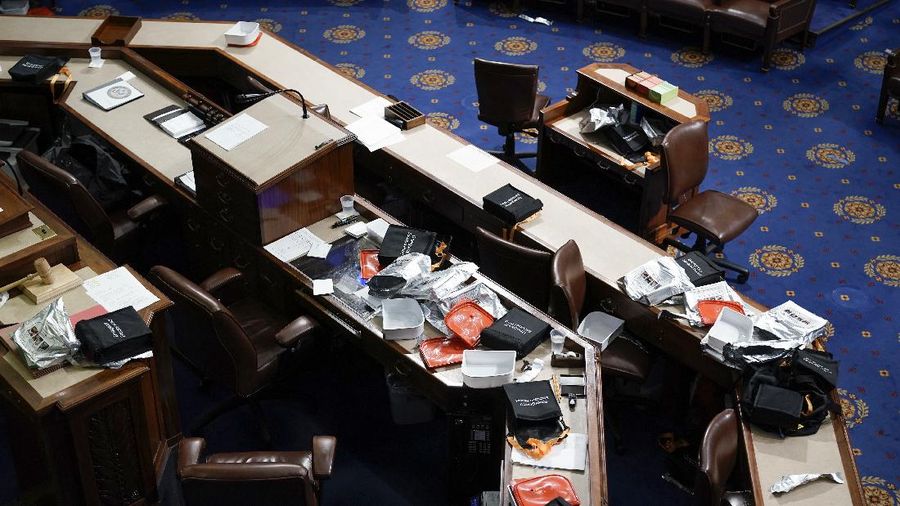 People shelter in the House gallery as protesters try to break into the House Chamber at the U.S. Capitol on Wednesday, Jan. 6, 2021, in Washington. (AP Photo/Andrew Harnik)